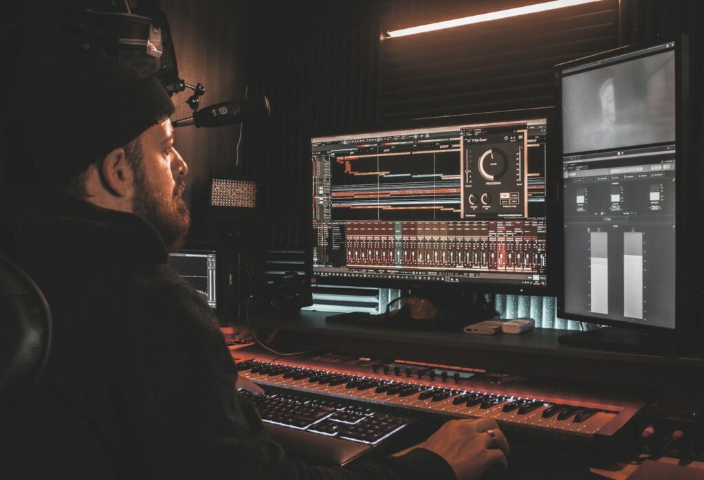 Man in Black Jacket Using VST Plugins and An Audio Mixer