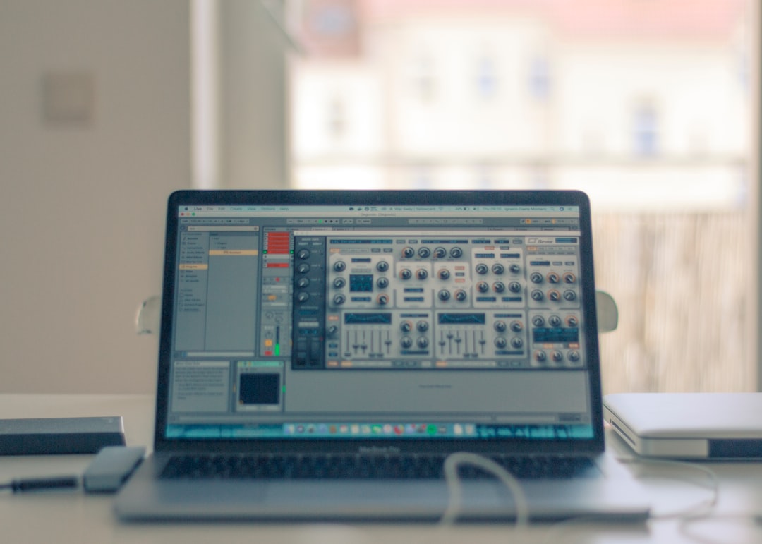 turned-on MacBook Pro on white table near window