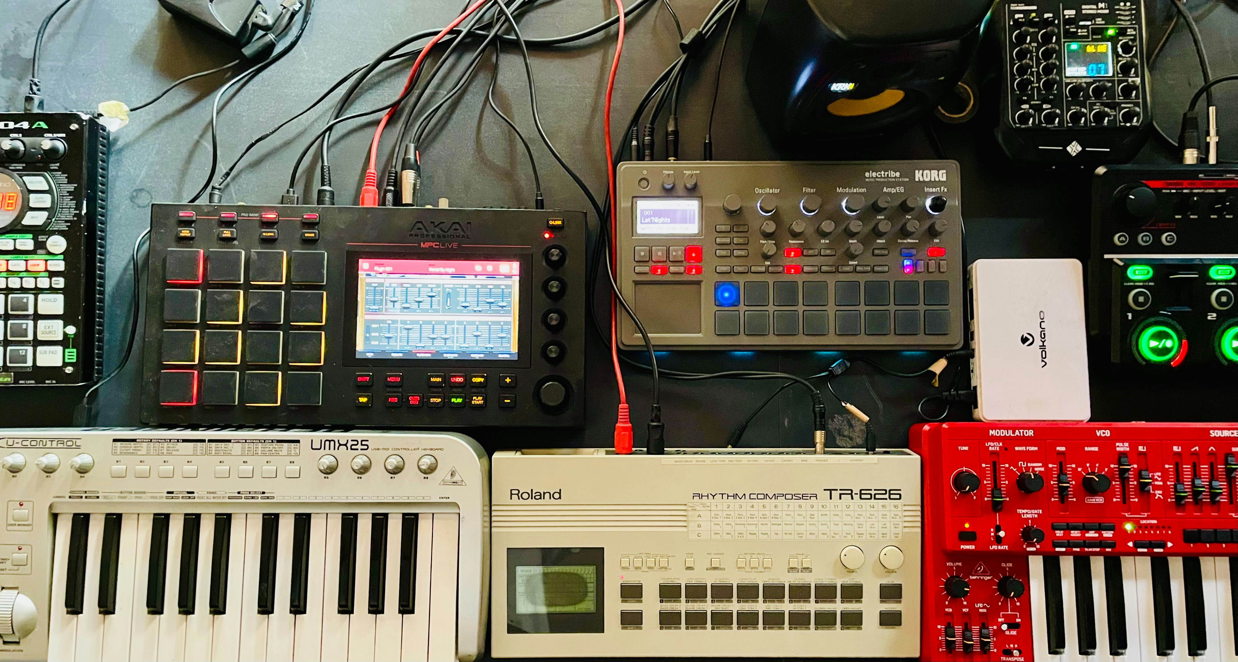 Synthesizers and drum machines by Uniphonic a bunch of electronic equipment sitting on top of a table