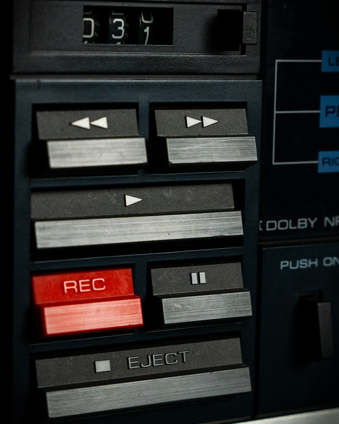 Close view of cassette tape player control buttons in a recording studio at Orbital 101 Studio. by Uniphonic A close up of a machine with buttons and buttons